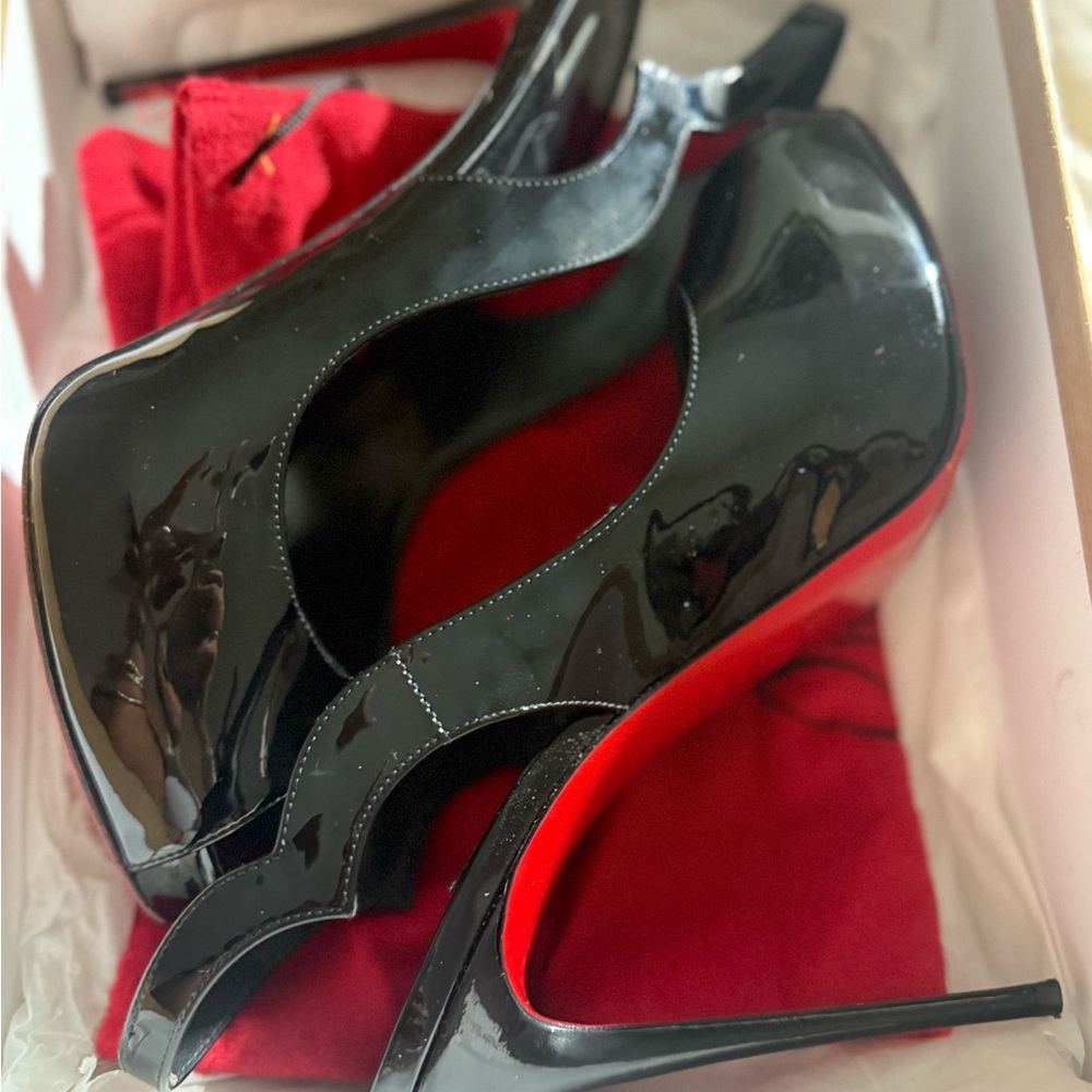 Christian Louboutin black patent sling back peep hole high heels.